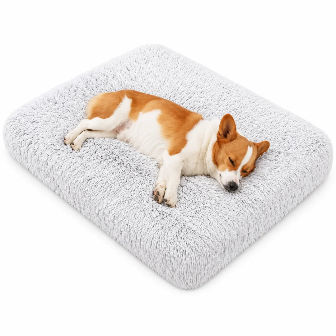 Corgi dog sleeping soundly on a plush gray rectangular faux fur pet bed.